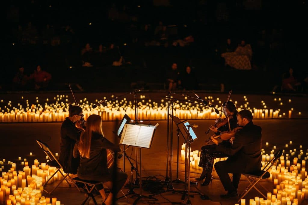 quartet performing on stage with candles at a Candlelight concert.