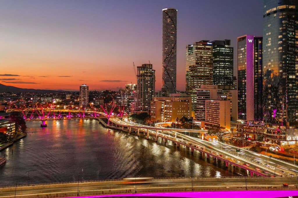 an aerial photo of the brisbane city skyline at sunset