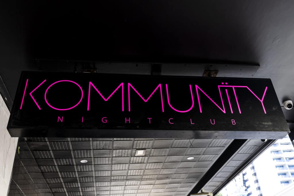 a photo of a pink and black night club sign
