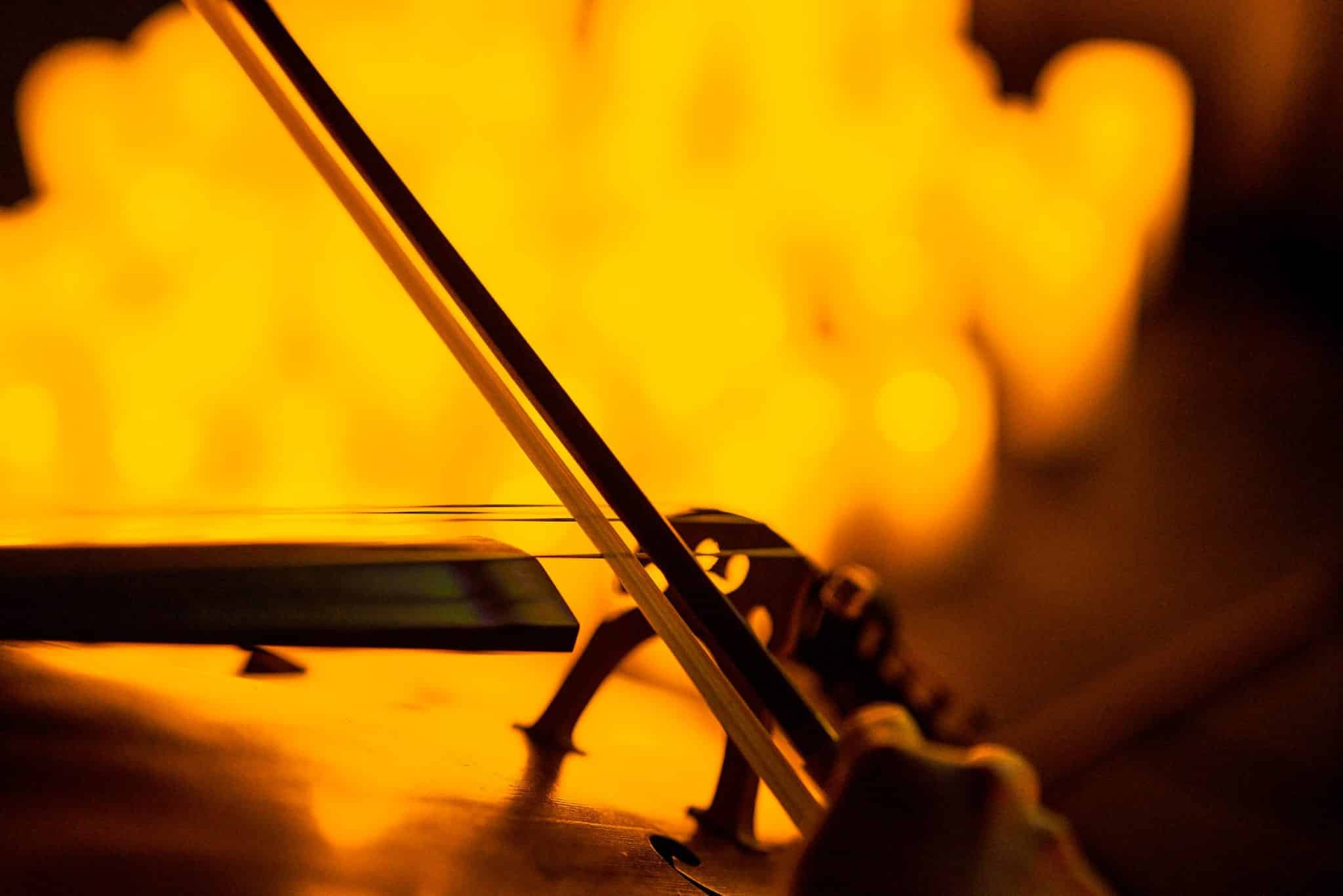 A close-up shot of a bow playing a string instrument at a Candlelight concert. 