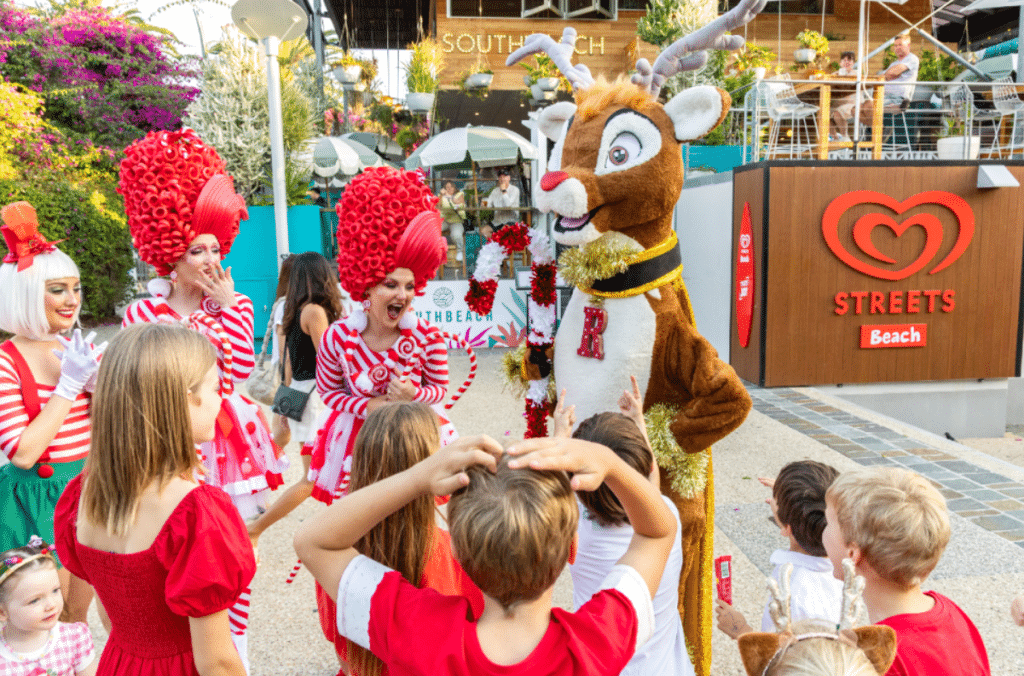 a photo of kids gathered around costumed characters such as a reindeer