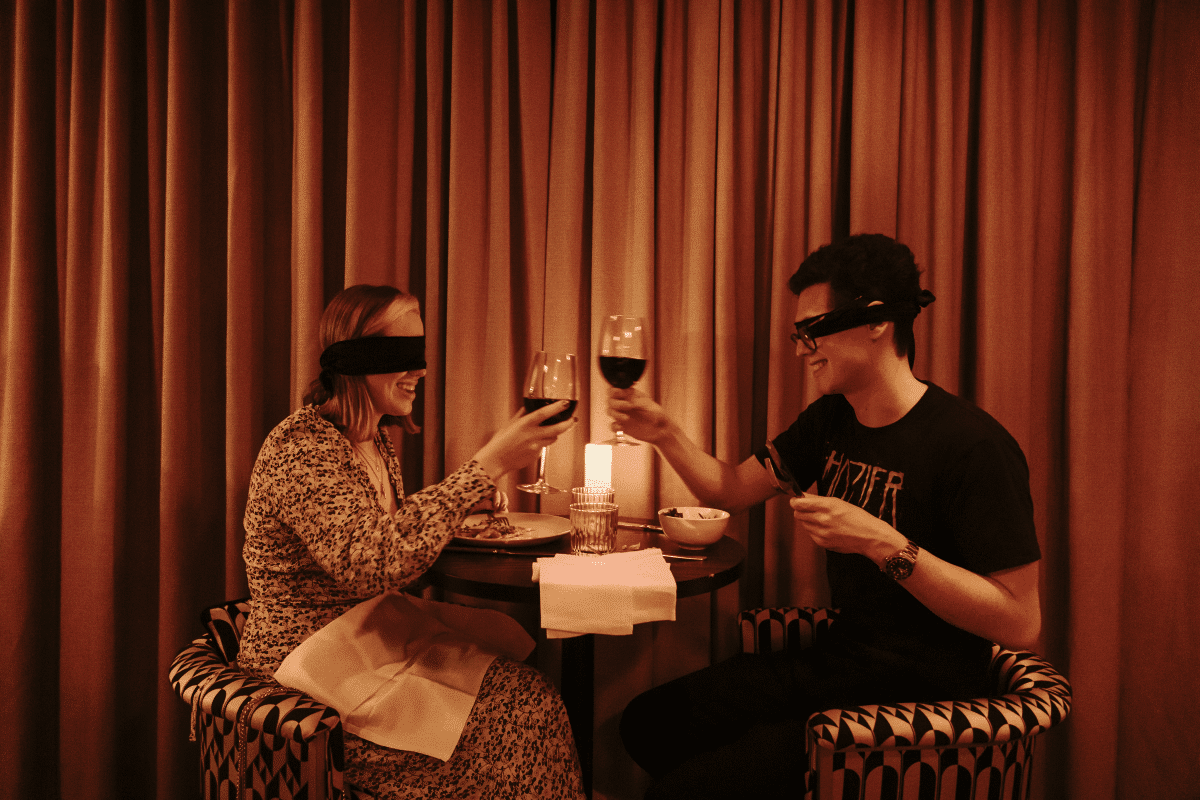A couple toasting at the Dining in the Dark experience.