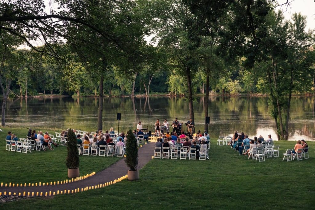 A picture of Candlelight Open Air at Mississippi Gardens along the river taken from the back of the audience