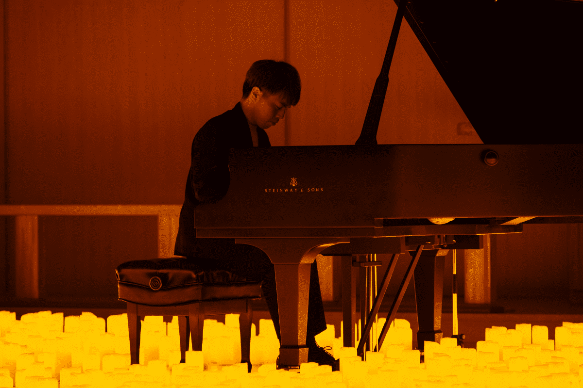 A pianist performs by candlelight