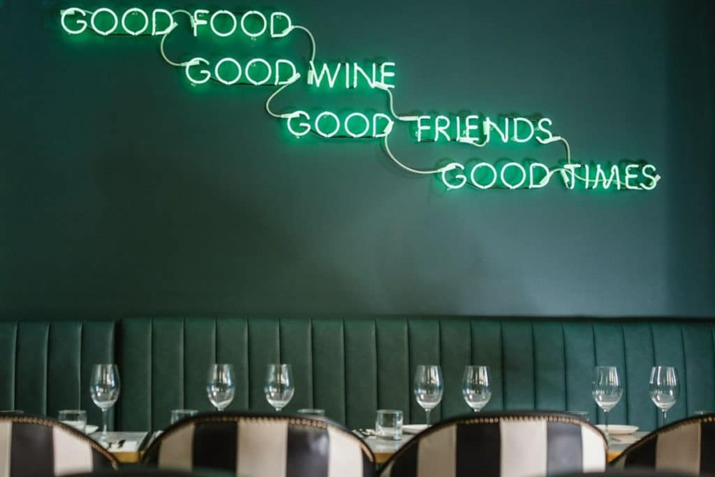 a photo of a neon sign in an green hued restaurant