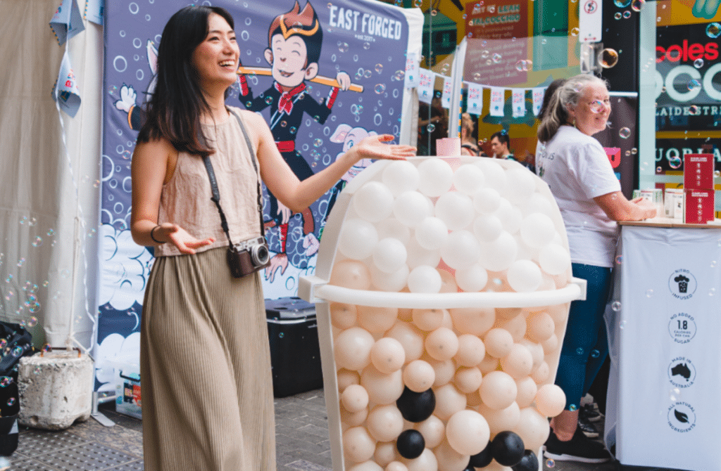 a photo of a woman in front of a giant bubble tea stand